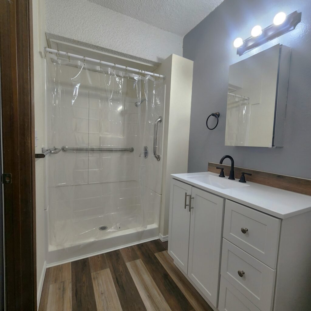 bathroom with walk-in shower with a handle bar, and