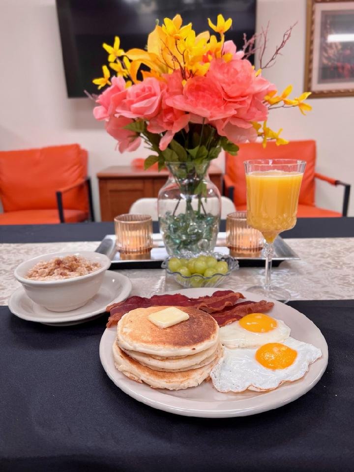 breakfast meal with pancakes eggs and orange juice