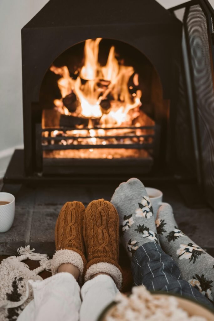 Cozy scene of a senior relaxing near a crackling fireplace, wrapped in a warm blanket, enjoying the warmth and comfort of the autumn season