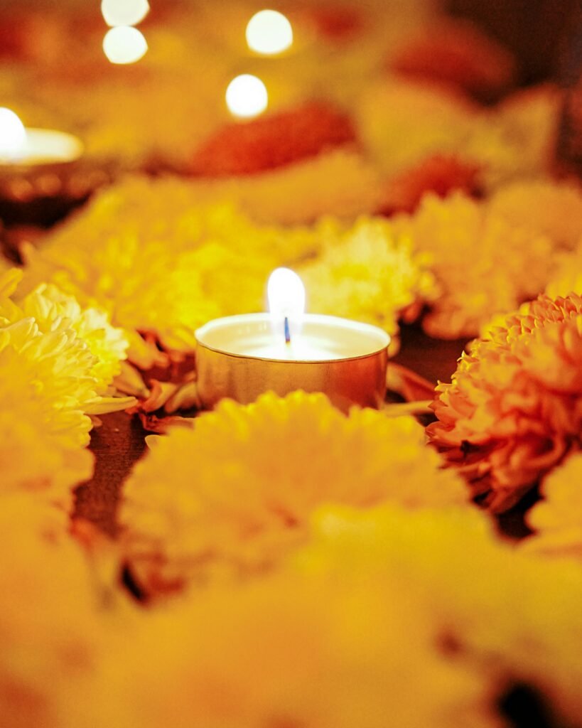 A candle surrounded by vibrant orange and yellow flowers, creating a warm and cozy autumn ambiance.