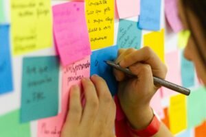 "A wall covered with colorful sticky notes, each with positive messages and expressions of gratitude. The notes are arranged neatly, creating a vibrant and uplifting display."