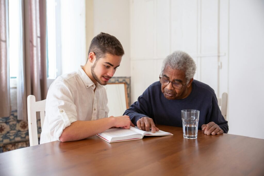 young man talking to his grandfather and showing him a notebook