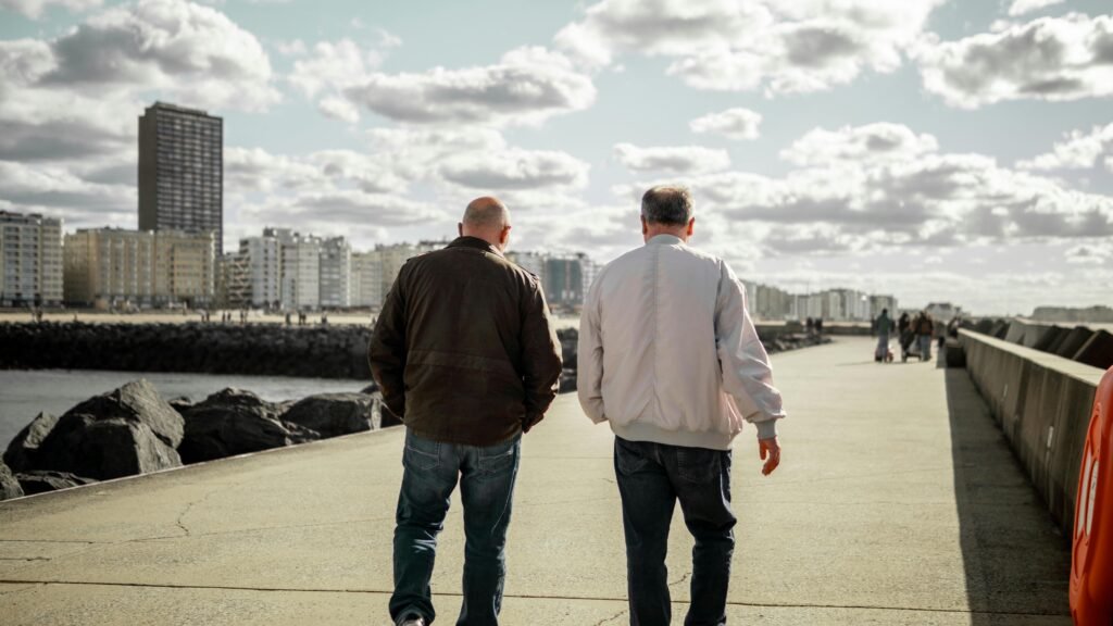 two old friends walking with a view of tall buildings in front