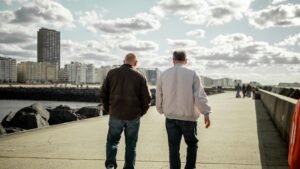 two old friends walking with a view of tall buildings in front