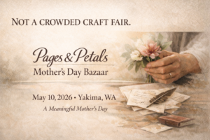 Vintage-style promotional image for the 2026 Pages & Petals Mother’s Day Bazaar in Yakima, WA. Features soft cream tones, a hand holding delicate spring flowers, handwritten letters, and a quill pen. Elegant serif text reads: “Not a crowded craft fair. Pages & Petals Mother’s Day Bazaar – May 10, 2026 – A Meaningful Mother’s Day.”